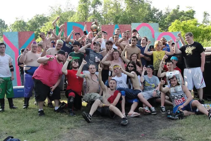 Large crew photo outdoors in front of a painted mural wall